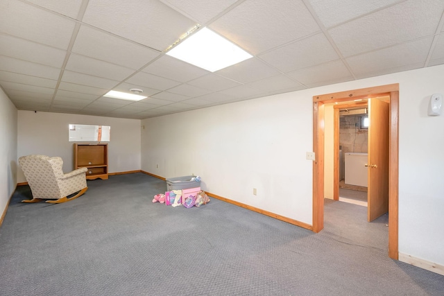 interior space with a paneled ceiling, carpet, and baseboards