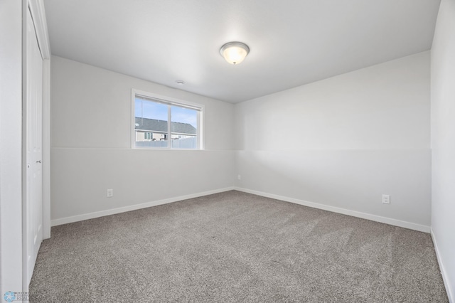 carpeted empty room with baseboards
