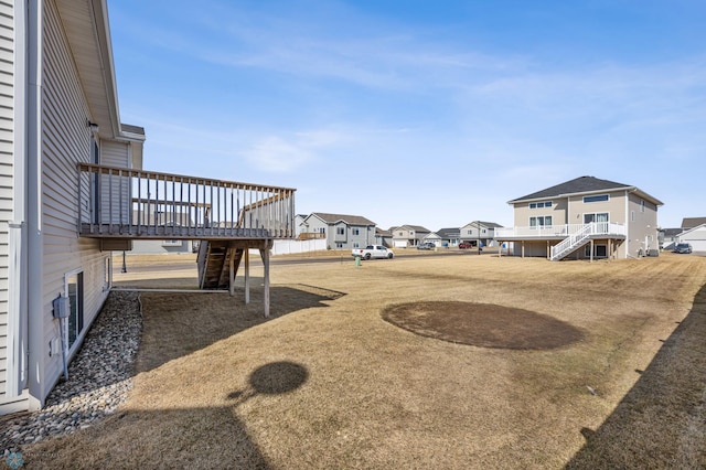 view of yard with stairs, a residential view, and a wooden deck