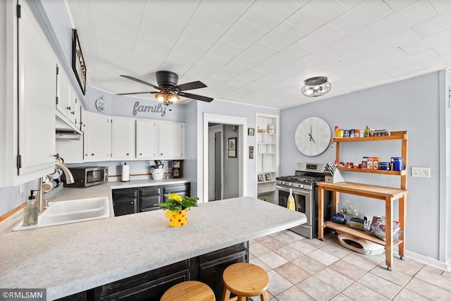 5664 County Road 7 SW, Howard Lake, MN 55349 - kitchen with a peninsula, a sink, white cabinetry, light countertops, and appliances with stainless steel finishes