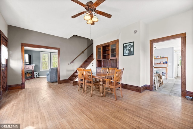 5664 County Road 7 SW, Howard Lake, MN 55349 - dining room with a ceiling fan, stairs, baseboards, and light wood finished floors