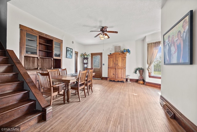 5664 County Road 7 SW, Howard Lake, MN 55349 - dining room featuring light wood finished floors, stairway, baseboards, and a ceiling fan