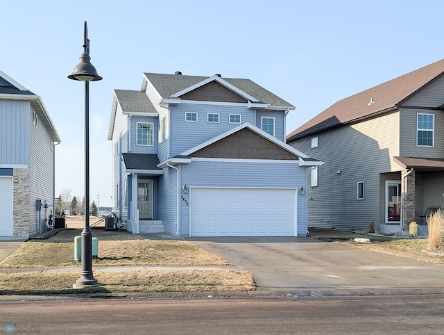 view of front of property with cooling unit, a garage, and driveway