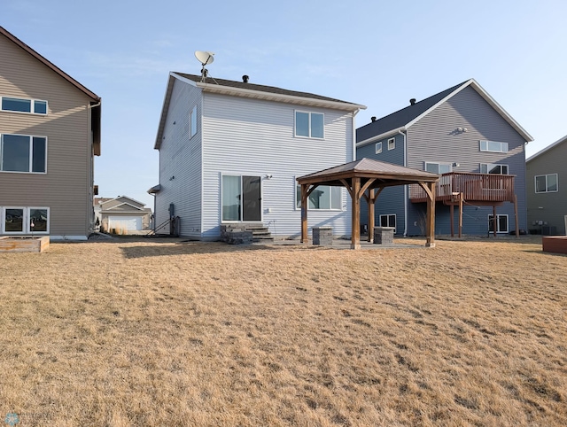 back of property featuring a gazebo, a yard, and entry steps