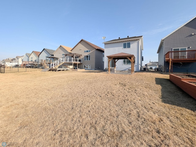 back of property featuring a gazebo and a residential view