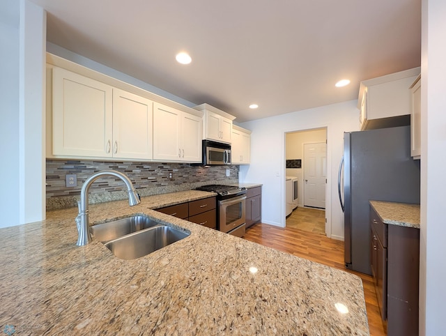 kitchen featuring a sink, light stone countertops, tasteful backsplash, and stainless steel appliances