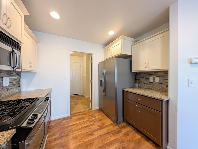 kitchen featuring recessed lighting, appliances with stainless steel finishes, light wood-type flooring, and baseboards