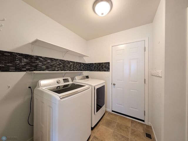 laundry room with baseboards, independent washer and dryer, and laundry area