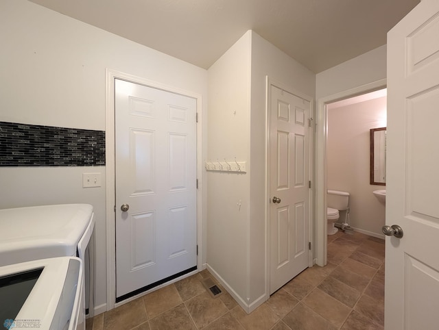 laundry area with washing machine and clothes dryer and baseboards