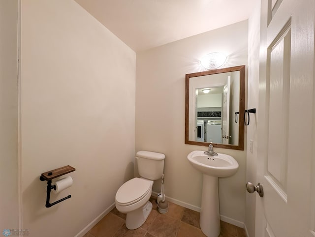 half bath featuring tile patterned floors, toilet, and baseboards