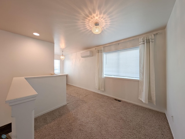 unfurnished room with visible vents, light carpet, an AC wall unit, recessed lighting, and baseboards