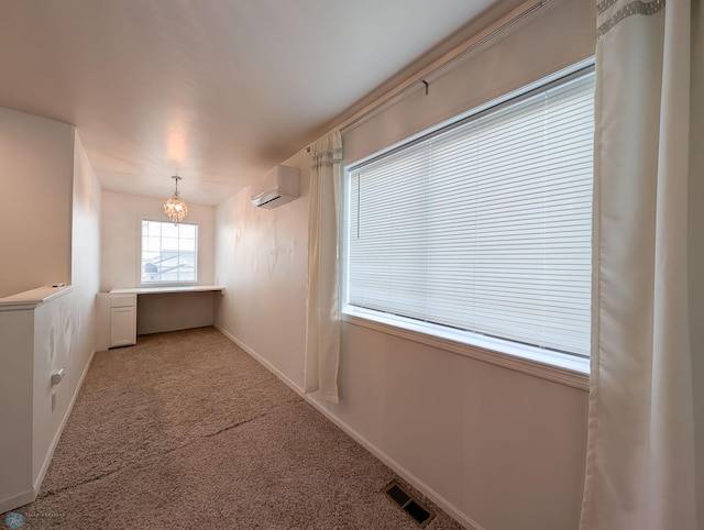 empty room featuring baseboards, visible vents, a wall mounted air conditioner, carpet flooring, and a chandelier