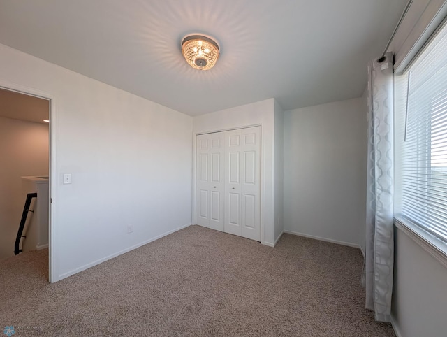 unfurnished bedroom with a closet, baseboards, and carpet