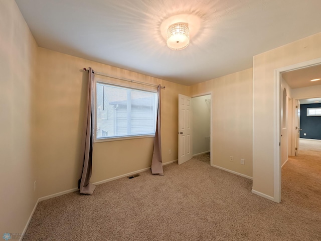 unfurnished bedroom with visible vents, baseboards, and carpet