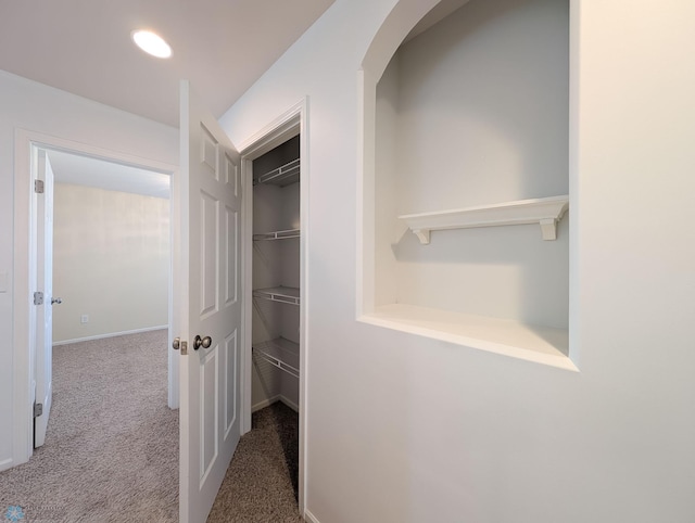 hallway featuring baseboards and carpet floors