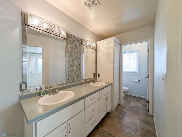 full bathroom featuring a sink, visible vents, toilet, and double vanity