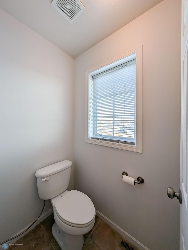 bathroom featuring tile patterned floors, toilet, baseboards, and visible vents