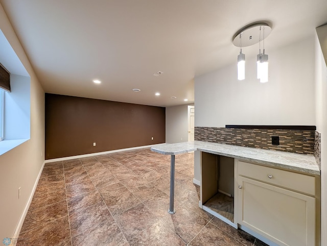 interior space featuring pendant lighting, tasteful backsplash, recessed lighting, baseboards, and light stone countertops