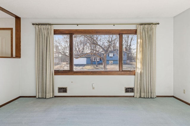 carpeted spare room with heating unit and baseboards