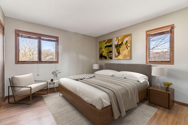 bedroom with baseboards and light wood finished floors