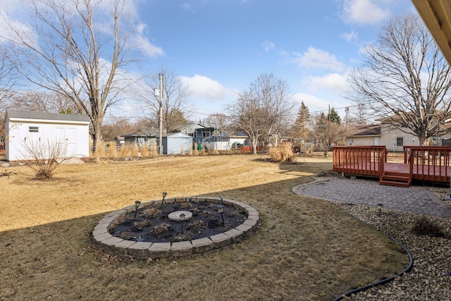 view of yard featuring a deck, an outbuilding, and a storage unit