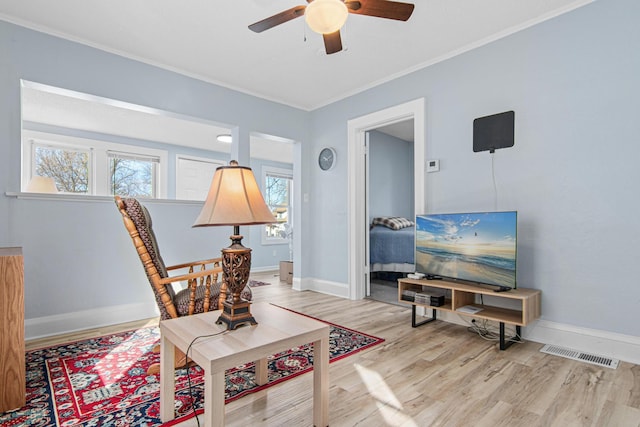 sitting room with a ceiling fan, wood finished floors, visible vents, and a wealth of natural light