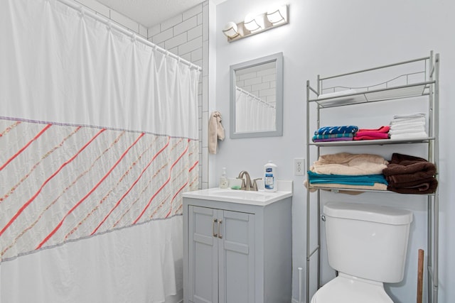 bathroom featuring vanity, curtained shower, and toilet