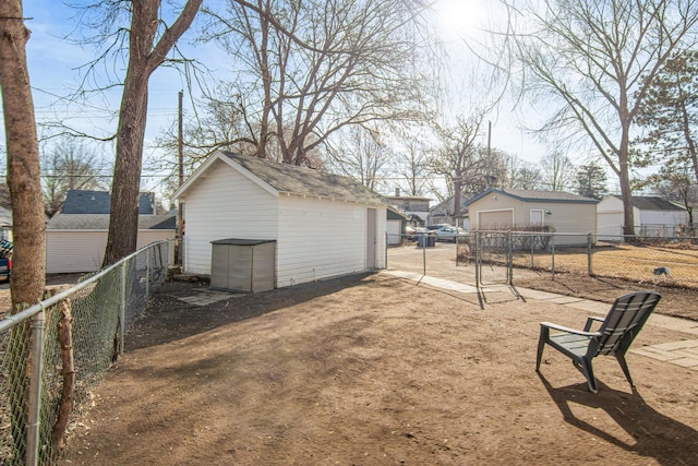 view of yard with a fenced backyard, a residential view, an outdoor structure, and a garage