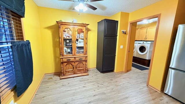 interior space featuring freestanding refrigerator, light wood-style floors, a textured ceiling, a ceiling fan, and separate washer and dryer