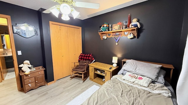 bedroom with a closet, ceiling fan, and light wood-style floors