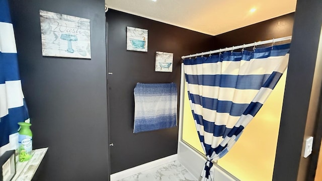 bathroom with baseboards, shower / tub combo with curtain, and marble finish floor