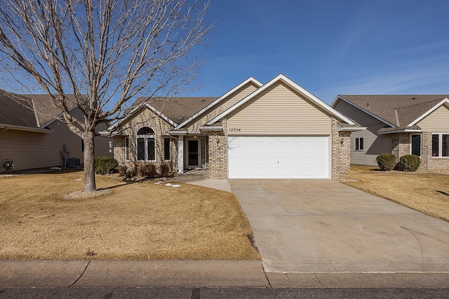 view of front of property with brick siding, cooling unit, an attached garage, and driveway