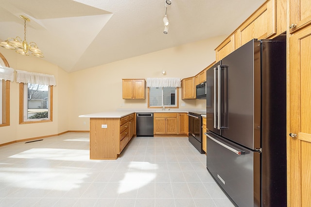 kitchen with black appliances, a sink, a peninsula, light countertops, and vaulted ceiling