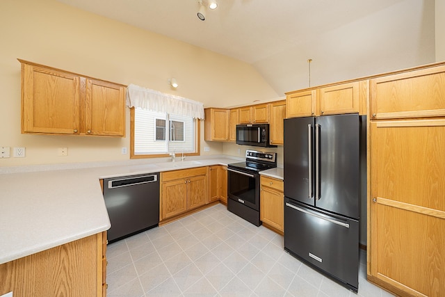 kitchen with a sink, lofted ceiling, black appliances, and light countertops