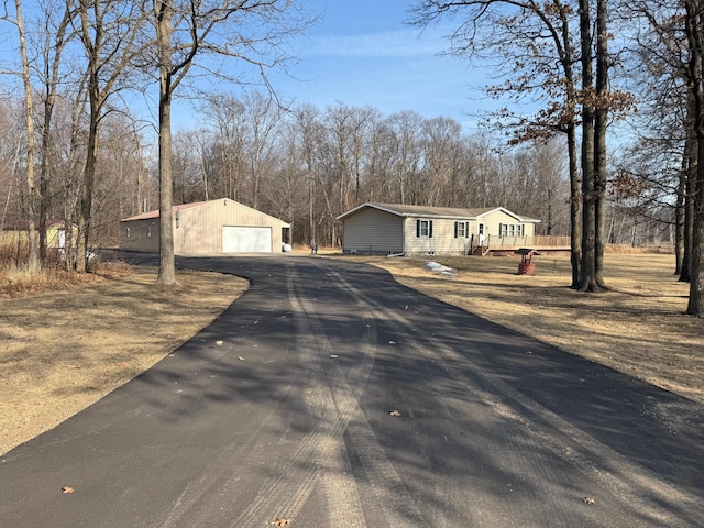 view of front of property featuring a deck, a detached garage, an outdoor structure, and crawl space