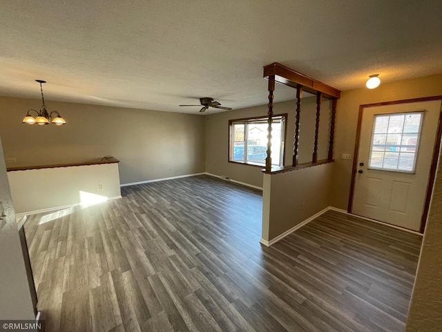 foyer entrance featuring baseboards, a textured ceiling, dark wood-style flooring, and ceiling fan with notable chandelier