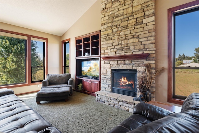 carpeted living area featuring a stone fireplace and vaulted ceiling