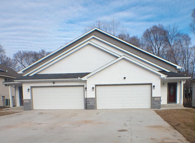 single story home featuring an attached garage, stone siding, driveway, and stucco siding