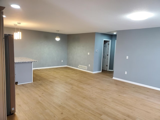 spare room with recessed lighting, visible vents, light wood-style flooring, and baseboards