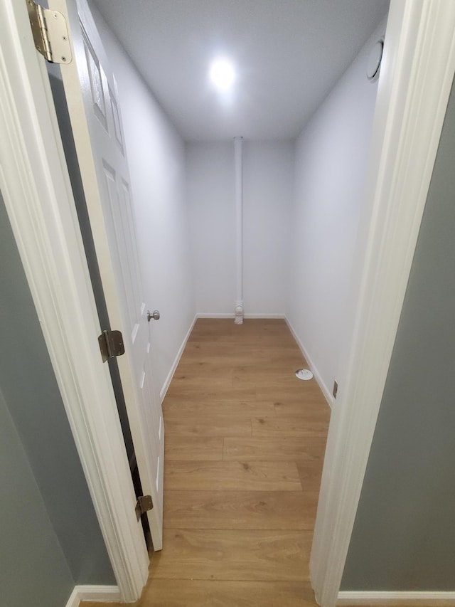 hall featuring baseboards and light wood-style floors