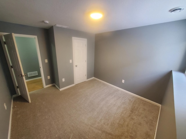 unfurnished bedroom with visible vents, baseboards, and carpet floors