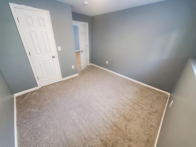 unfurnished bedroom featuring carpet flooring and baseboards