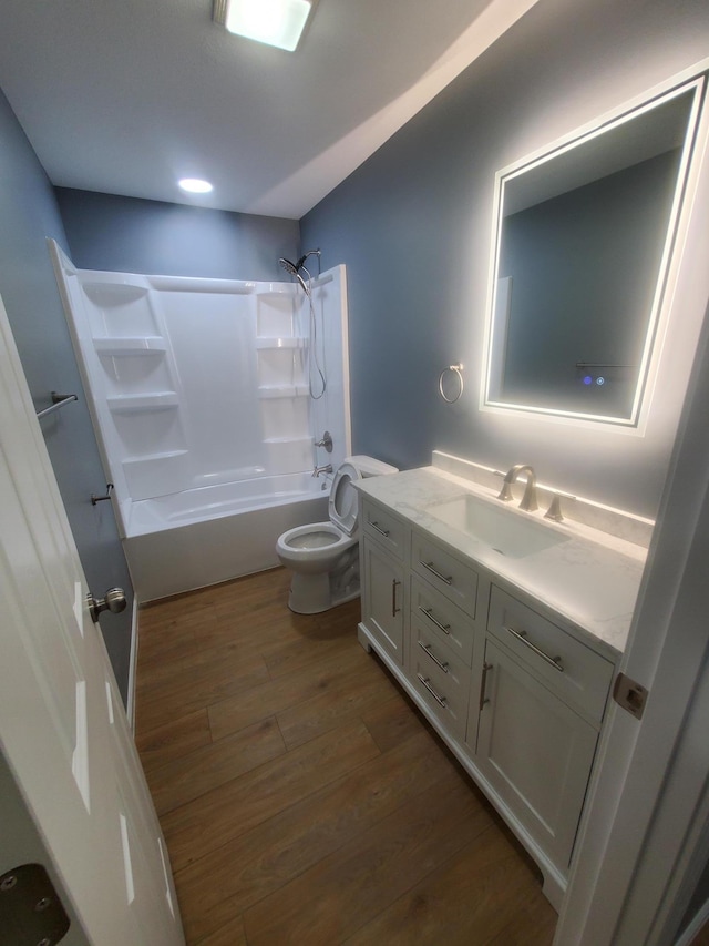 bathroom featuring bathing tub / shower combination, wood finished floors, vanity, and toilet