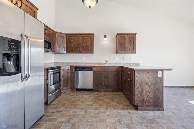 6098 55th Ave S, Fargo, ND 58104 - kitchen featuring a sink, appliances with stainless steel finishes, a peninsula, light countertops, and a towering ceiling