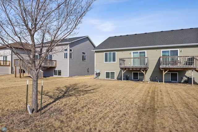 6098 55th Ave S, Fargo, ND 58104 - back of property featuring a deck, central AC unit, and a lawn