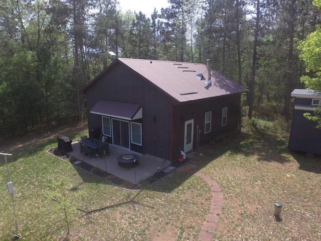 30349 Johnson Creek Trl, Webb Lake, WI 54830 - rear view of house featuring a patio area, a yard, a metal roof, an outdoor fire pit, and a standing seam roof