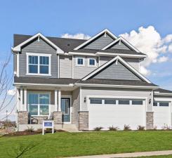 craftsman-style house featuring stone siding, a garage, and a front yard