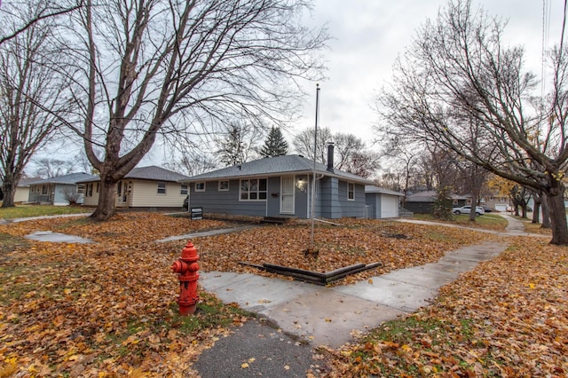 view of front of home featuring an attached garage and a shingled roof