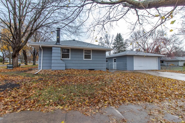 view of front of house featuring a garage, roof with shingles, an outdoor structure, and concrete driveway