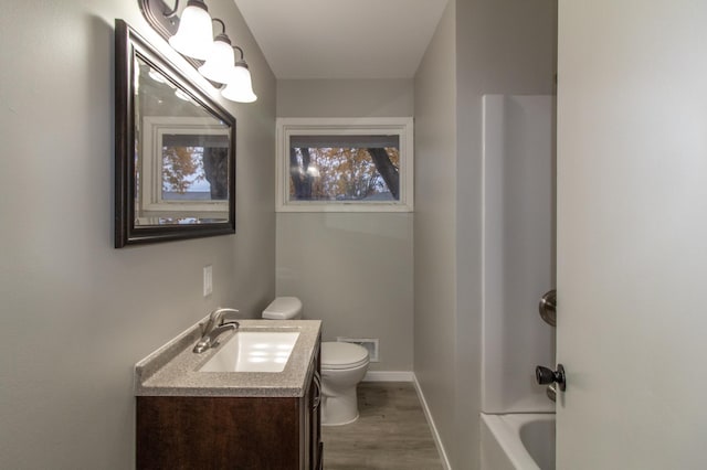 full bath with vanity, wood finished floors, baseboards, visible vents, and toilet